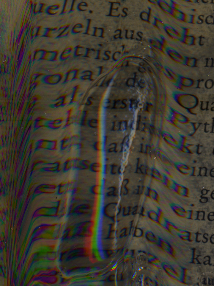 One huge soapy bubble sits on the book page. Letters are mostly distorted. Words are in German.