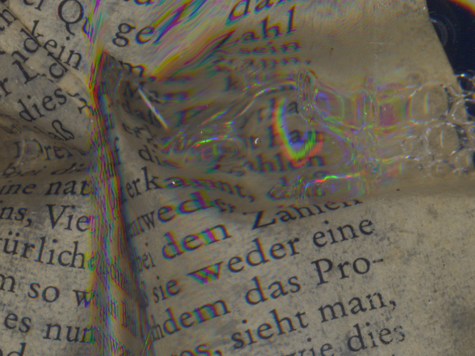 A section of a sheet of wet paper carrying text and bubbles. Crumpled a little. Words are in German.
